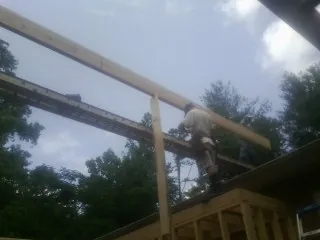 Carpenter setting a ridge beam over a new addition frame — Ice Dam Removal by Roofing Brothers in Wills Point