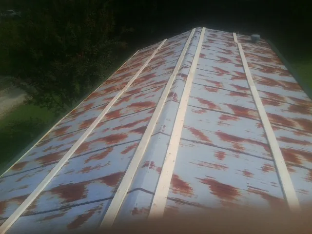 Rusted metal roof panels with new wood purlins before replacement — Storm Damage Roof Repair in Wills Point by Roofing Brothers