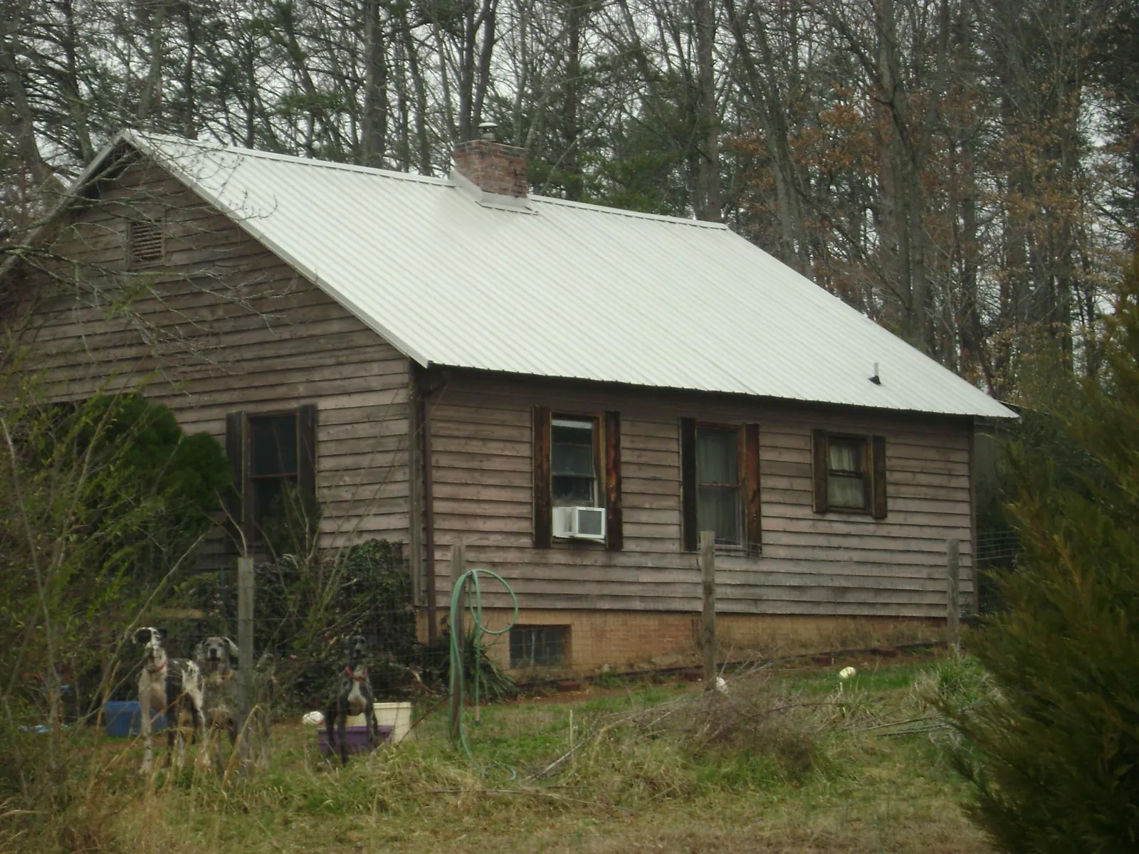 White metal roof on an old wood sided farmhouse, from a Asphalt Shingle Roof Repair job in Wills Point